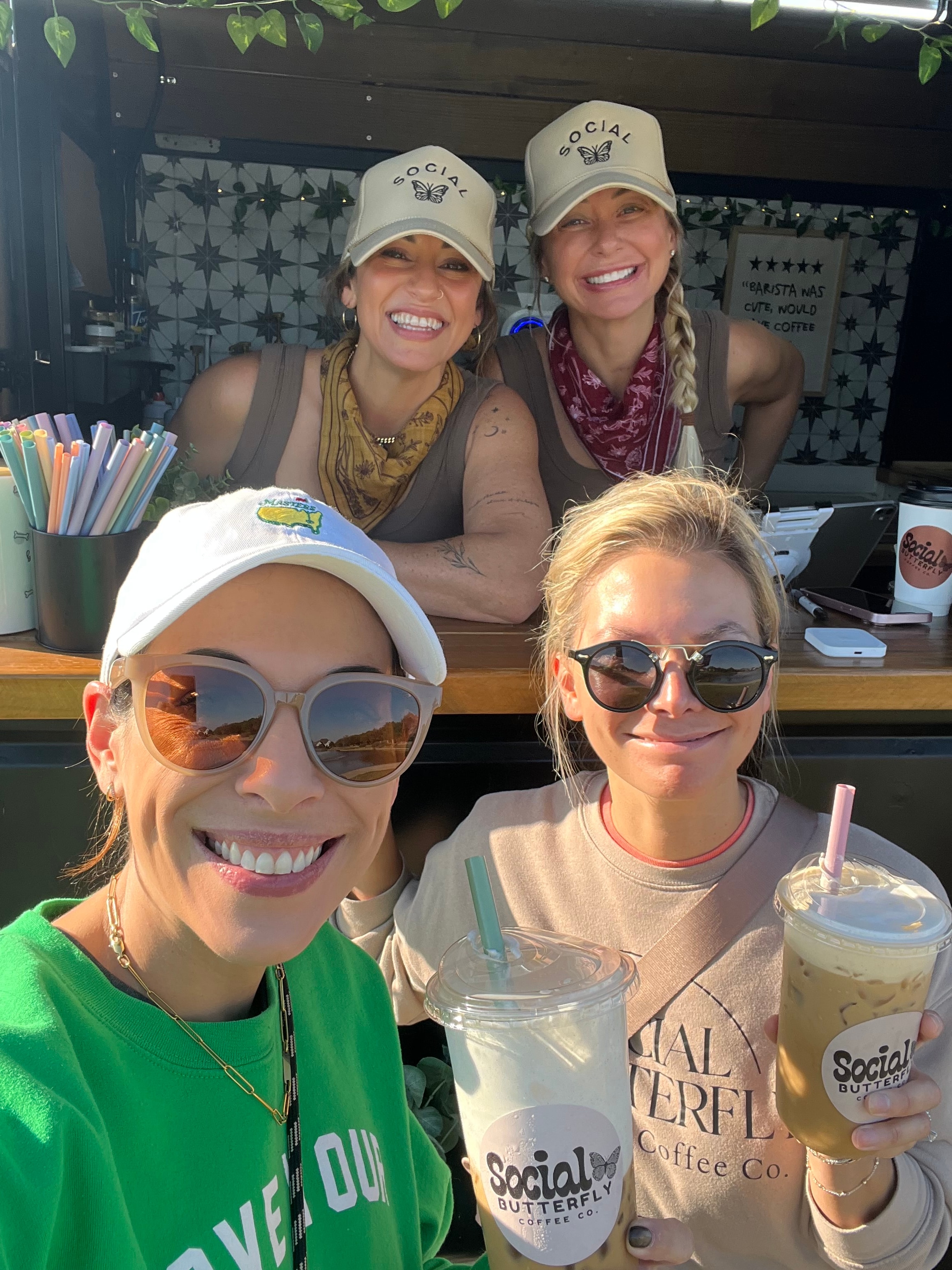 Group of friends with Social Butterfly Coffee Co branded cups at a popup