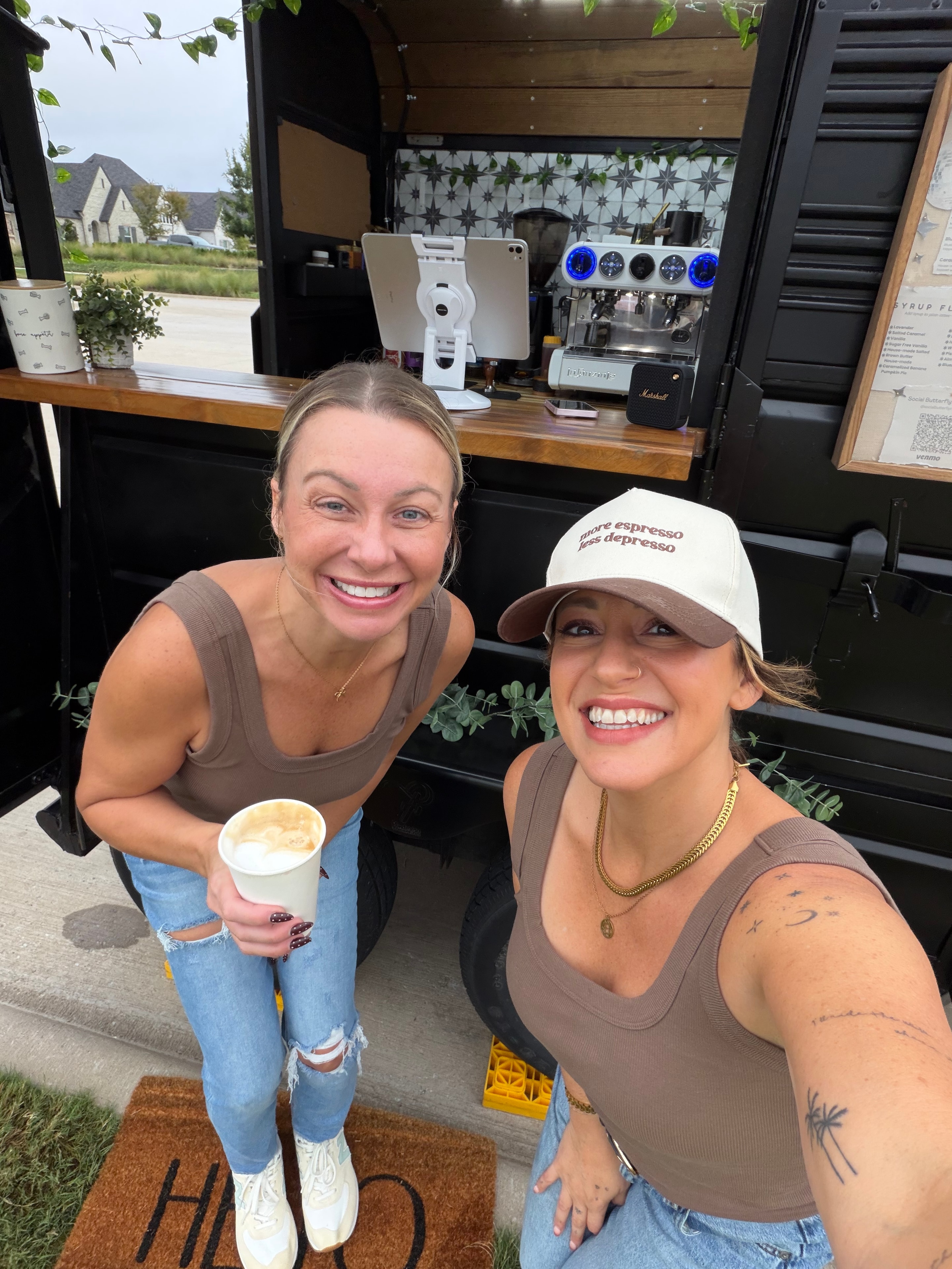 Two guests smiling at a Social Butterfly Coffee Co community popup